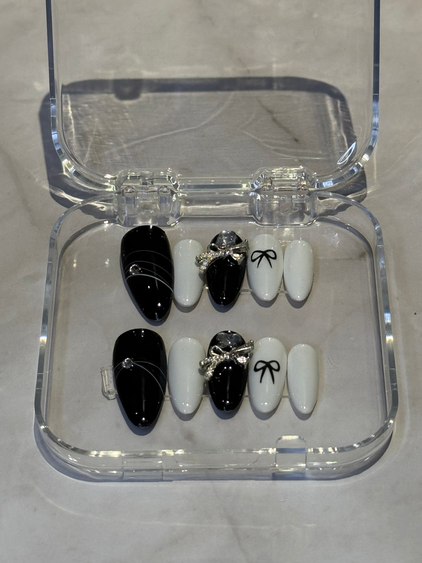 Medium almond nails with charming black and white embellishments. 