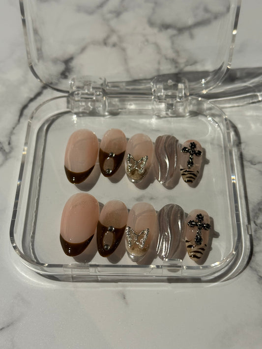 Brown nails featuring classic French tips accented with shimmering silver details. This mystical design combines gel finish with delicate charms for an ethereal, sophisticated look that balances elegance with an air of mystery. 