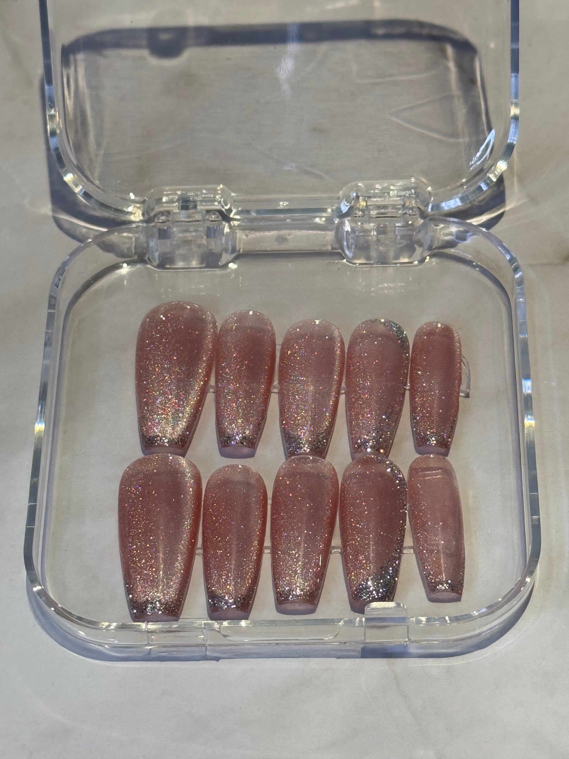 Coffin-shaped press-on nails with a mesmerizing hypnotic glaze finish. Features a soft pink color with striking cat eye effect and delicate hand-painted silver lines for a sophisticated, fashion-forward look. Perfect for adding instant glamour to any style