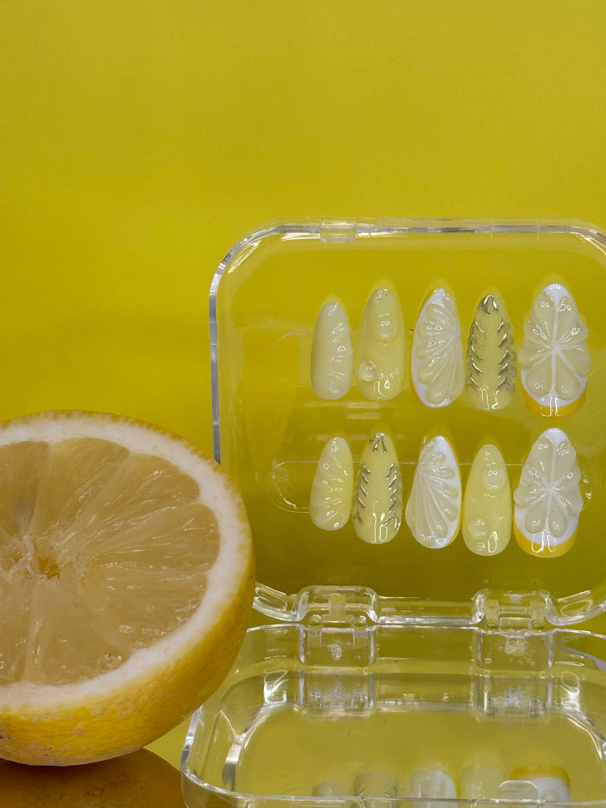 Almond medium long press-on nails with 3D handcrafted fruit gel details. Each set features vibrant yellow and citrus-inspired designs, meticulously created by hand. Perfect for those seeking bold, artistic nail art with a fresh, summery aesthetic. Ready to wear straight from the box.