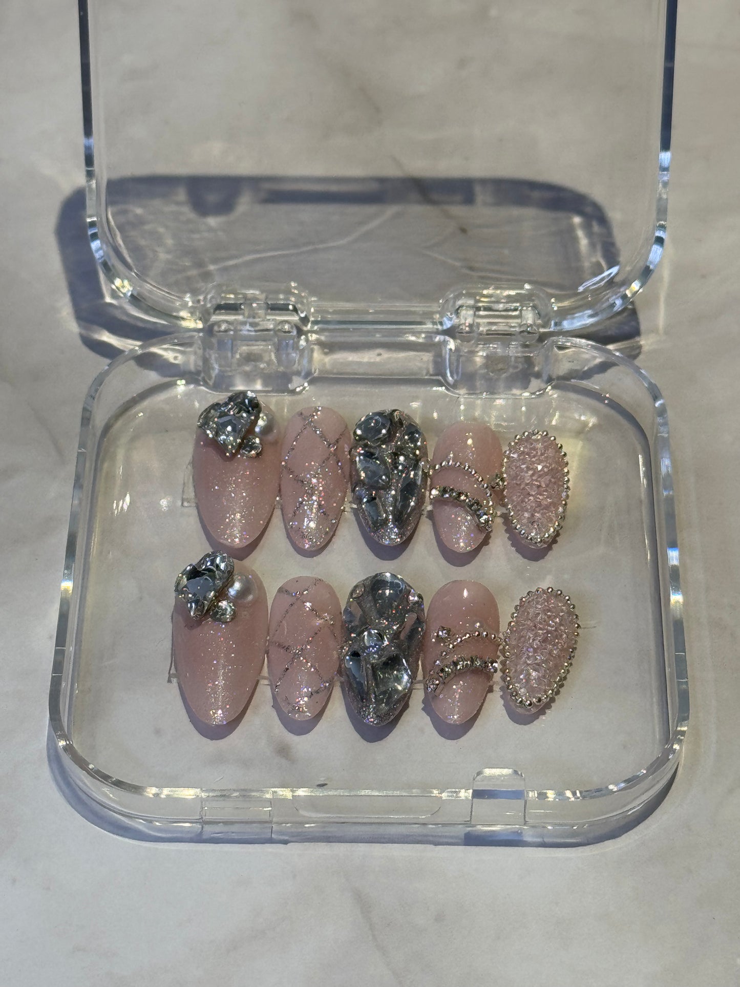 Immerse yourself in dreamy elegance with Kylies sweet dreams — medium almond press-on nails featuring soft, sophisticated styling. Each set showcases big handmade details , decorated with charms and shimmering rhinestones for a touch of luxury and individuality