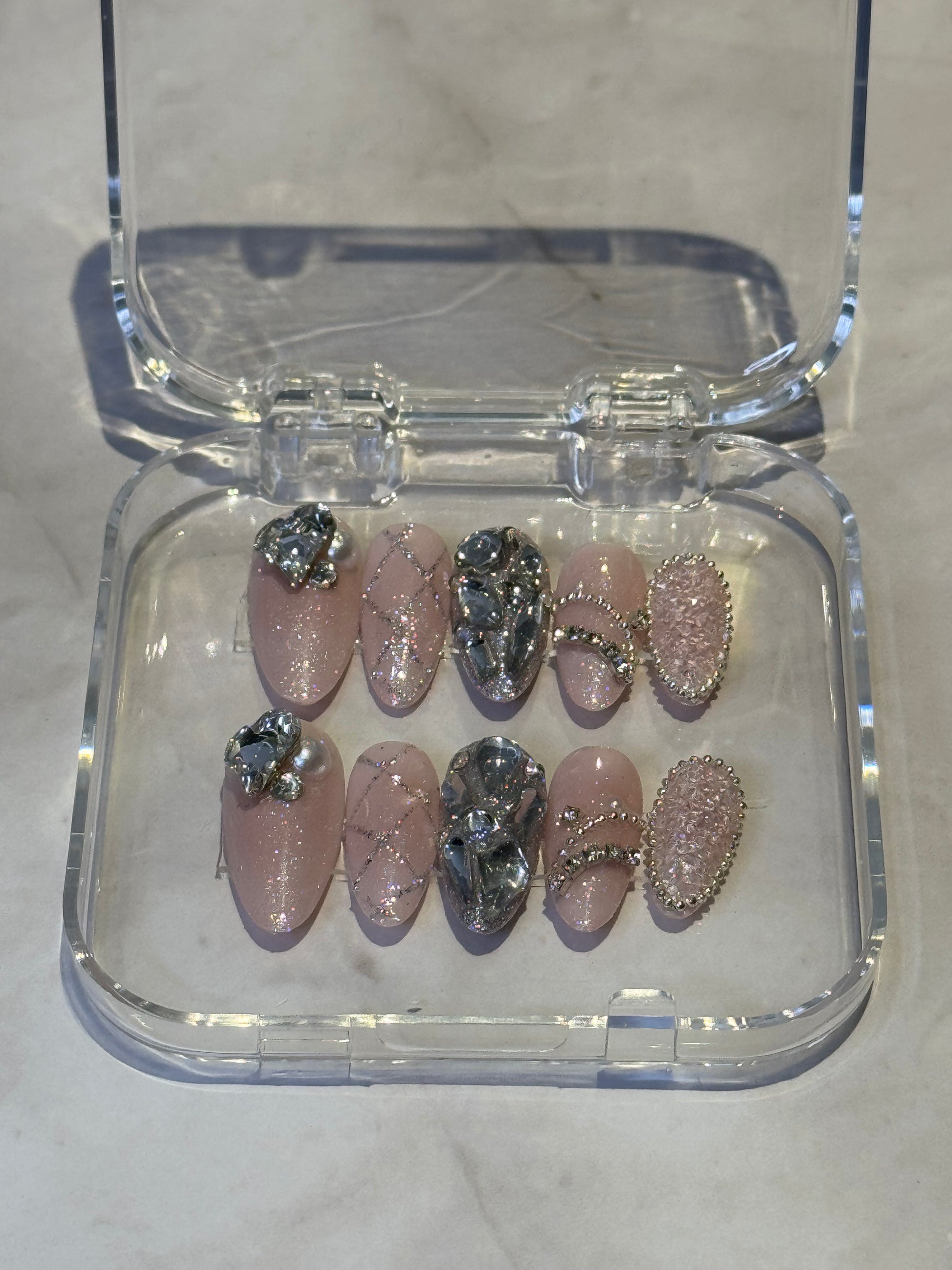 Immerse yourself in dreamy elegance with Kylies sweet dreams — medium almond press-on nails featuring soft, sophisticated styling. Each set showcases big handmade details , decorated with charms and shimmering rhinestones for a touch of luxury and individuality