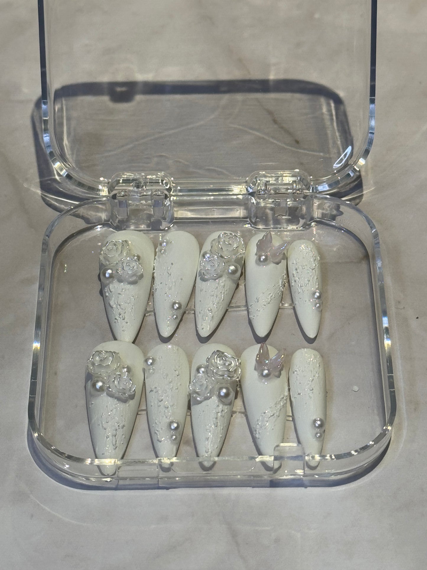 Stilletto nails in white , with pearl and cute charms . reuseable , fakenails
