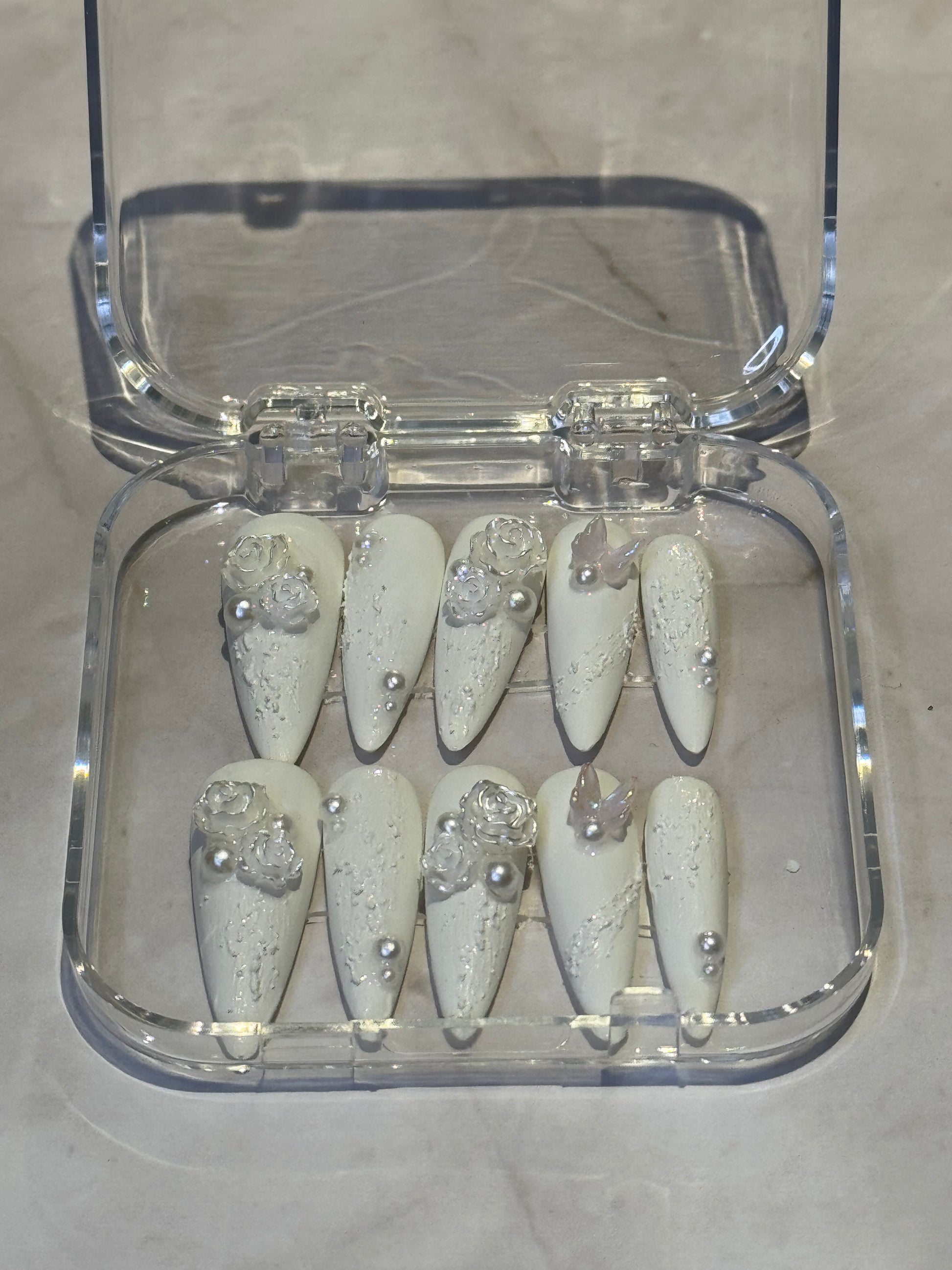 Stilletto nails in white , with pearl and cute charms . reuseable , fakenails