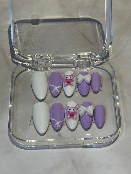 Handmade press-on nails featuring adorable baby cry charms with delicate bows. Kawaii-inspired look.