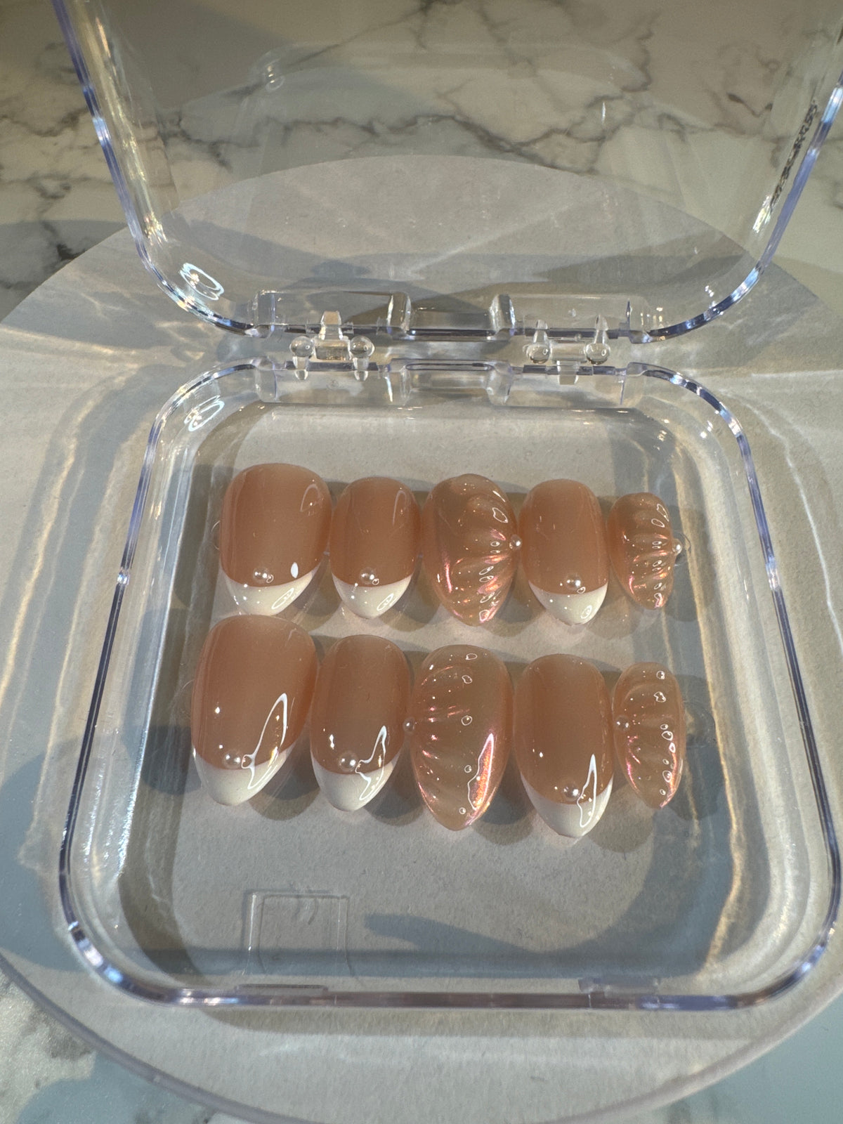 Luxury press-on nails, French manicure, light pink with 3D pattern, glossy.
