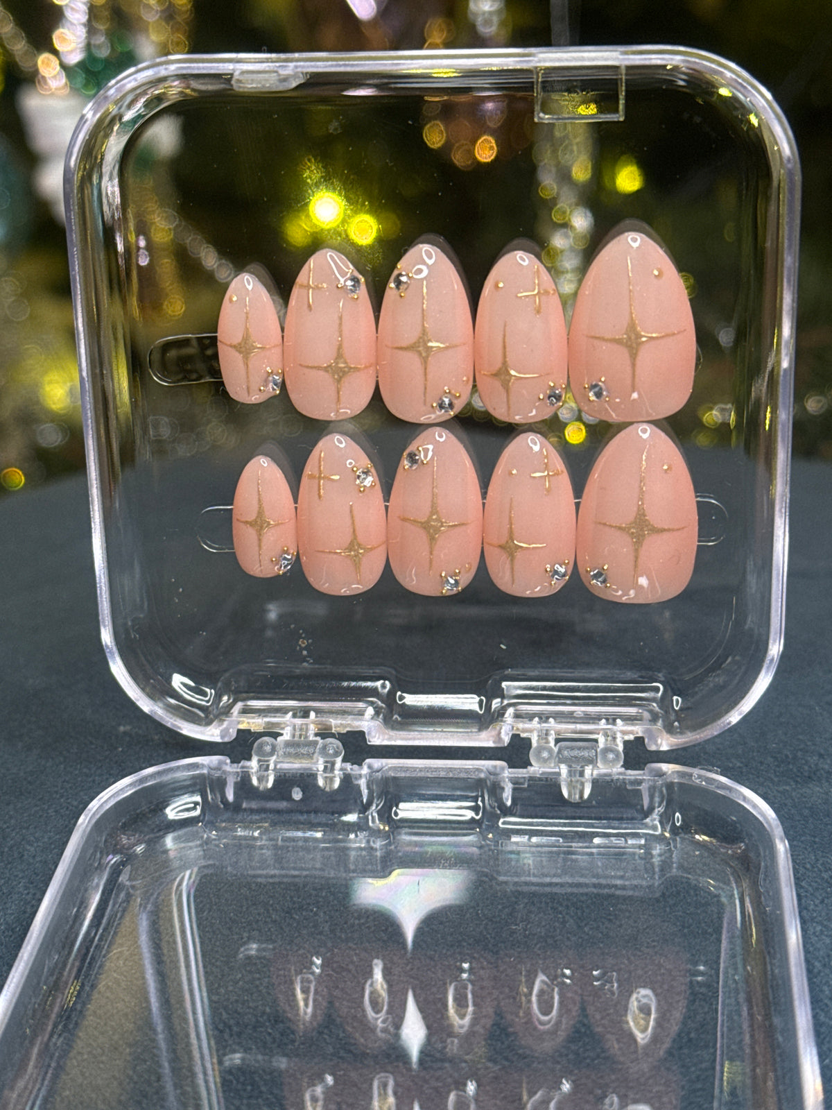 Luxury press-on nails, light peach-colored, gold stars, diamonds, Huntrix.
