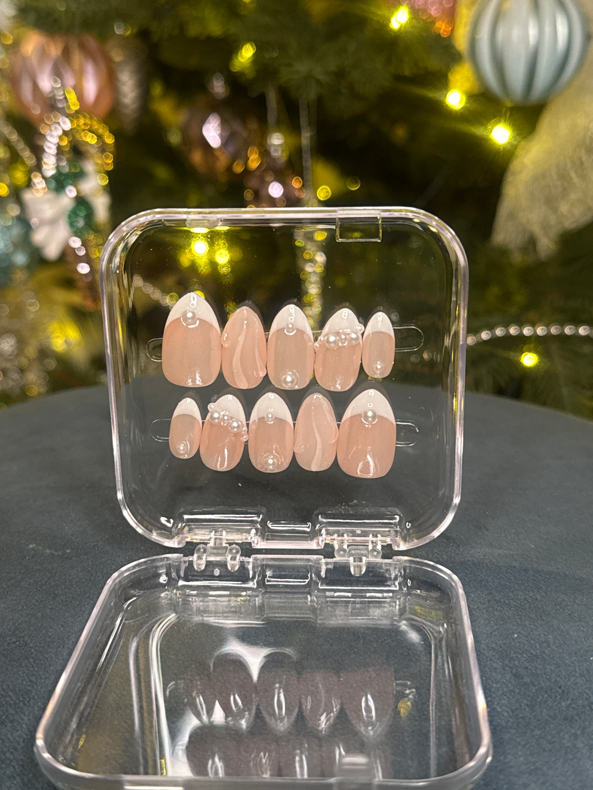 Luxury press-on nails, light nude shade, pearls, French manicure.
