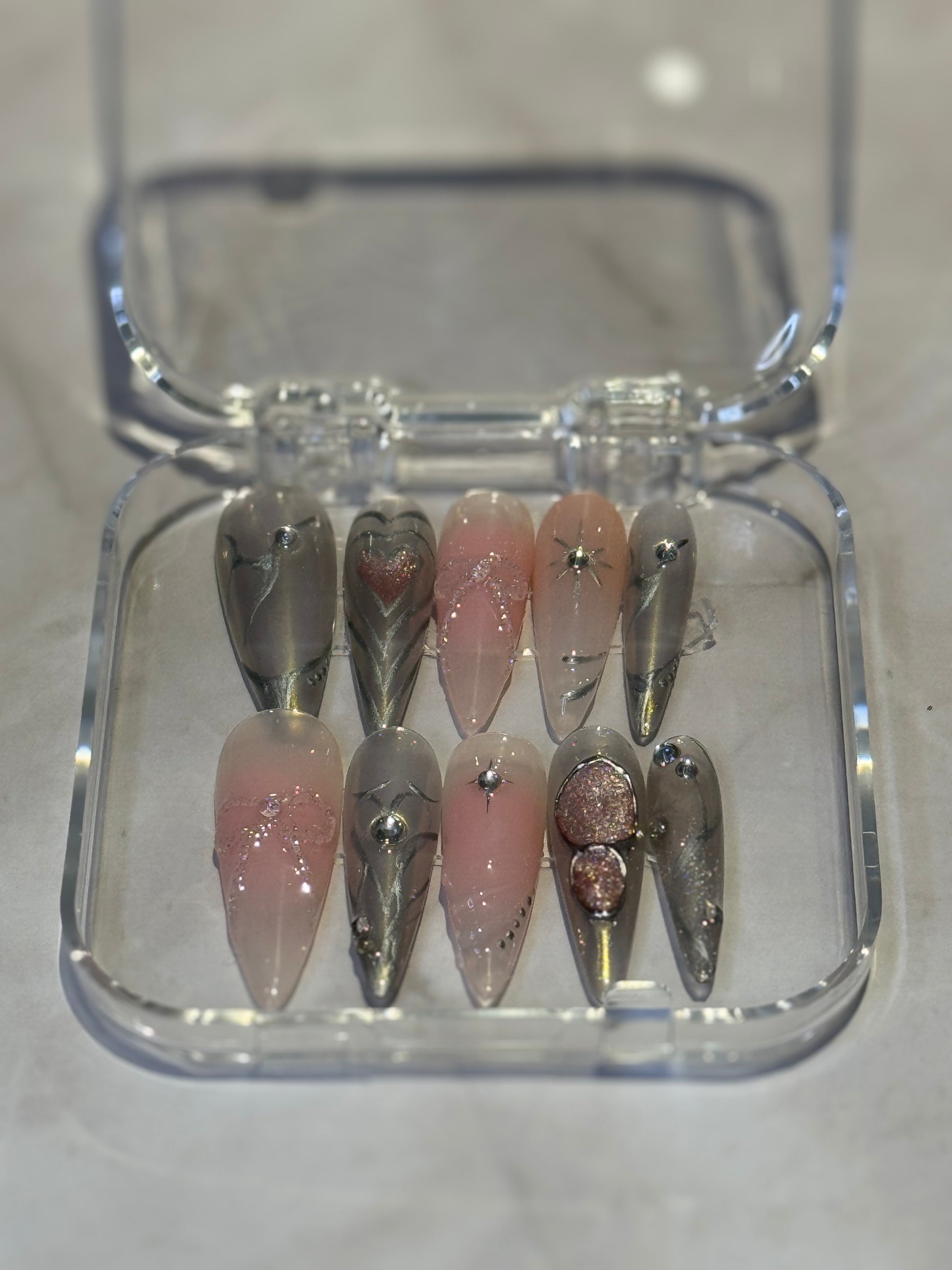 A combo of pink and silver nails,cateye effct silver painted lines,and gel with rhinestones.beautiful press-on nails that stands out